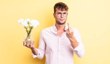 Genç ve yakışıklı bir adam sinirli, sinirli, asi ve agresif hissediyor. çiçek konsepti