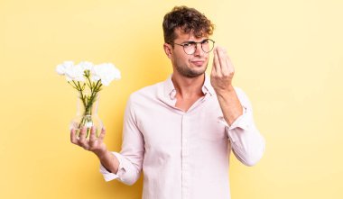 Genç yakışıklı adam kapiş ya da para hareketi yapıyor, sana ödemeni söylüyor. çiçek konsepti