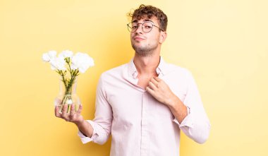 Genç yakışıklı adam kibirli, başarılı, pozitif ve gururlu görünüyor. çiçek konsepti