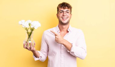 Genç yakışıklı adam heyecanlı ve şaşırmış görünüyor. çiçek konsepti