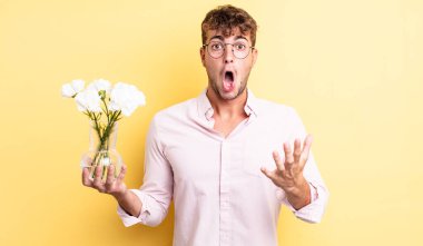 Genç yakışıklı adam, inanılmaz bir sürprizle şaşkına dönmüş ve hayrete düşmüştü. çiçek konsepti