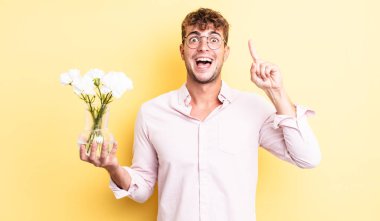 Genç yakışıklı bir adam bir fikri fark ettikten sonra mutlu ve heyecanlı bir dahi gibi hissediyor. çiçek konsepti