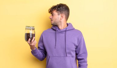 Profilde genç yakışıklı bir adam hayal kuruyor, hayal kuruyor ya da hayal kuruyor. kahve çekirdeği konsepti