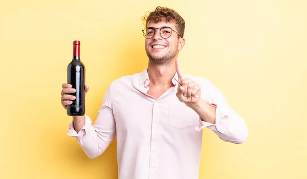Jovem Bonito Homem Sorrindo Orgulhosamente Confiantemente Fazendo Número Garrafa Vinho — Fotografia de Stock