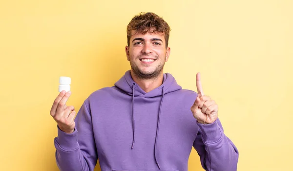 Young Handsome Man Smiling Looking Friendly Showing Number One Pills — Stock Photo, Image