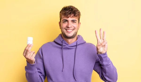 Jovem Bonito Homem Sorrindo Olhando Amigável Mostrando Número Três Pílulas — Fotografia de Stock