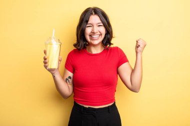 Genç ve güzel bir kadın şokta, gülüyor ve başarıyı kutluyor. Milkshake konsepti