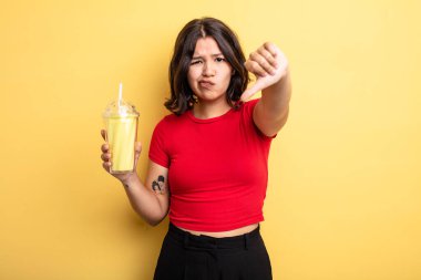 Genç ve güzel bir kadın kendini kötü hissediyor, baş parmağını kaldırıyor. Milkshake konsepti