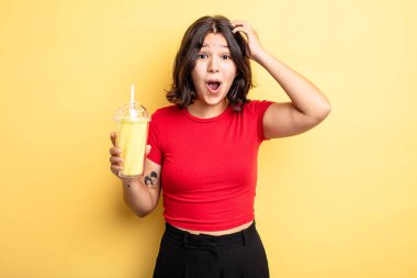 Genç ve güzel bir kadın mutlu, şaşkın ve şaşırmış görünüyor. Milkshake konsepti