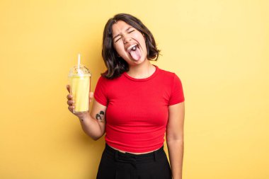 Neşeli ve asi tavırları olan genç ve güzel bir kadın, şaka yapıyor ve dilini dışarı çıkarıyor. Milkshake konsepti