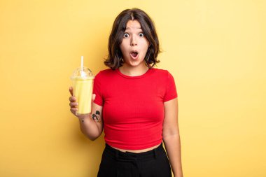 Genç ve güzel bir kadın çok şaşırmış ya da şaşkın görünüyor. Milkshake konsepti