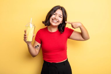 Genç ve güzel bir kadın, kendine güvenerek gülümsüyor. Milkshake konsepti