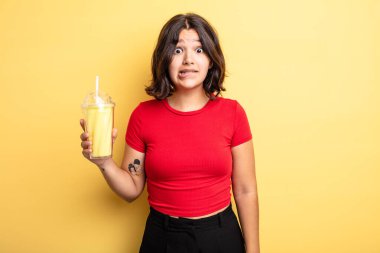 Genç, güzel bir kadın kafası karışmış ve şaşkın görünüyor. Milkshake konsepti