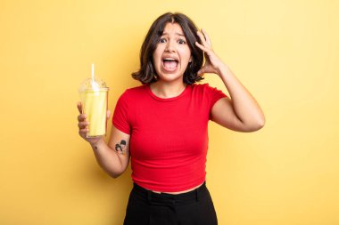 Genç ve güzel bir kadın ellerini havaya kaldırarak çığlık atıyor. Milkshake konsepti