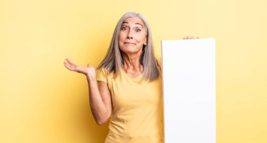 Orta yaşlı, güzel bir kadın şaşkın, şaşkın ve şüpheci hissediyor. boş tuval kavramı