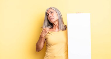 Orta yaşlı güzel bir kadın stresli, endişeli, yorgun ve hayal kırıklığına uğramış hissediyor. boş tuval kavramı