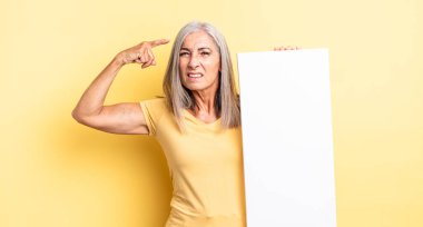 Orta yaşlı güzel bir kadın kafası karışık ve şaşkın hissediyor, deli olduğunu gösteriyor. boş tuval kavramı