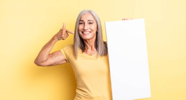 Orta yaşlı, güzel bir kadın, kendine güvenerek gülümsüyor. boş tuval kavramı