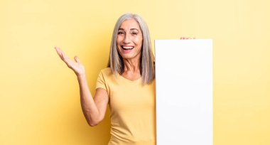 Orta yaşlı, güzel bir kadın kendini mutlu hissediyor. Bir çözüm ya da fikir bulduğuna şaşırıyor. boş tuval kavramı