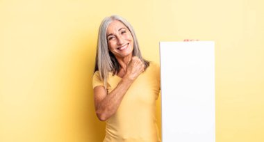 Orta yaşlı, güzel bir kadın kendini mutlu hisseder ve bir meydan okumayla yüzleşir ya da kutlama yapar. boş tuval kavramı