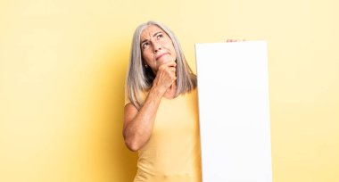 Orta yaşlı, düşünceli, kuşkulu ve kafası karışık bir kadın. boş tuval kavramı