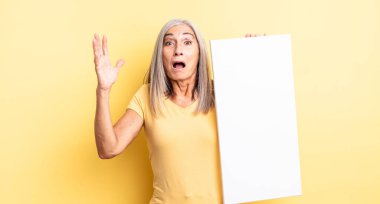 Orta yaşlı, güzel bir kadın ellerini havaya kaldırarak çığlık atıyor. boş tuval kavramı