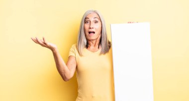 Orta yaşlı güzel bir kadın son derece şaşkın ve şaşırmış hissediyor. boş tuval kavramı