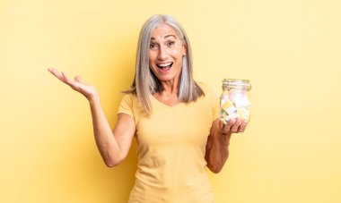 Orta yaşlı, güzel bir kadın inanılmaz bir şey karşısında mutlu ve şaşkın hissediyor. Şeker şişesi konsepti