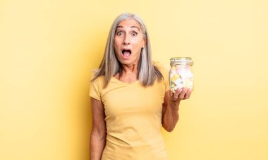 Orta yaşlı güzel bir kadın çok şaşırmış ya da şaşkın görünüyor. Şeker şişesi konsepti