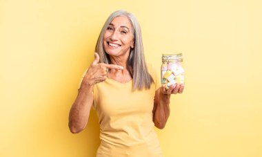 Orta yaşlı, güzel bir kadın heyecanlı ve şaşırmış görünüyor. Şeker şişesi konsepti