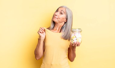 Orta yaşlı, güzel bir kadın kibirli, başarılı, pozitif ve gururlu görünüyor. Şeker şişesi konsepti