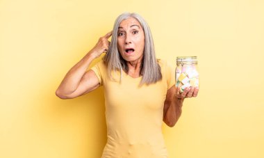 Orta yaşlı, güzel bir kadın şaşırmış görünüyor, yeni bir düşünce, fikir ya da konsept fark ediyor. Şeker şişesi konsepti