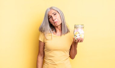 Orta yaşlı, güzel bir kadın üzgün ve mızmızlanıyor. Mutsuz bir bakışı var ve ağlıyor. Şeker şişesi konsepti