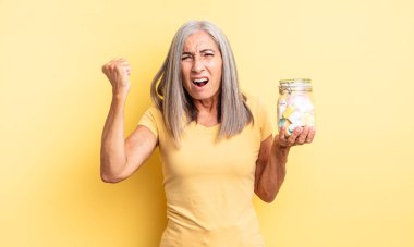 Orta yaşlı, güzel bir kadın sinirli bir ifadeyle agresif bir şekilde bağırıyor. Şeker şişesi konsepti