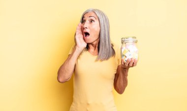Orta yaşlı, güzel bir kadın mutlu, heyecanlı ve şaşırmış hissediyor. Şeker şişesi konsepti