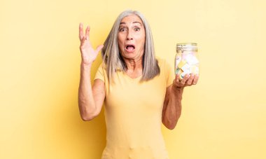 Orta yaşlı, güzel bir kadın ellerini havaya kaldırarak çığlık atıyor. Şeker şişesi konsepti