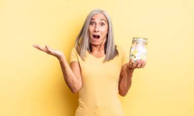 Orta yaşlı güzel bir kadın son derece şaşkın ve şaşırmış hissediyor. Şeker şişesi konsepti