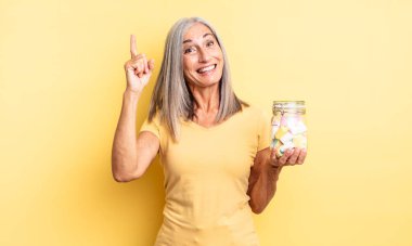 Orta yaşlı, güzel bir kadın bir fikri fark ettikten sonra mutlu ve heyecanlı bir dahi gibi hissediyor. Şeker şişesi konsepti