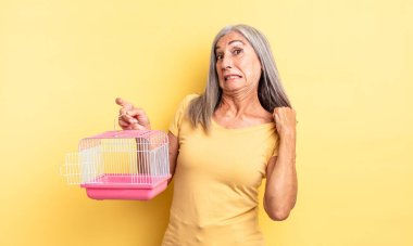 Orta yaşlı güzel bir kadın stresli, endişeli, yorgun ve hayal kırıklığına uğramış hissediyor. evcil hayvan kafesi veya hapishane konsepti