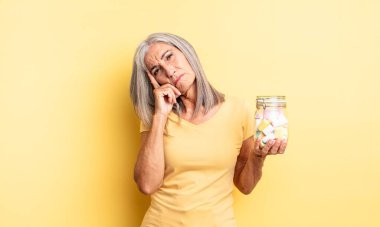 Orta yaşlı, güzel bir kadın bıkkın, yorgun ve uykulu hissediyor. Şeker şişesi konsepti