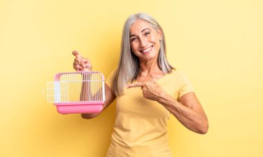 Orta yaşlı, güzel bir kadın heyecanlı ve şaşırmış görünüyor. evcil hayvan kafesi veya hapishane konsepti