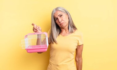 Orta yaşlı, güzel bir kadın üzgün ve mızmızlanıyor. Mutsuz bir bakışı var ve ağlıyor. evcil hayvan kafesi veya hapishane konsepti