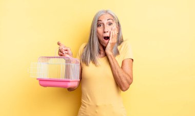 Orta yaşlı, güzel bir kadın şok olmuş ve korkmuş hissediyor. evcil hayvan kafesi veya hapishane konsepti