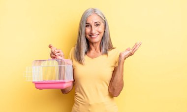 Orta yaşlı, güzel bir kadın kendini mutlu hissediyor. Bir çözüm ya da fikir bulduğuna şaşırıyor. evcil hayvan kafesi veya hapishane konsepti