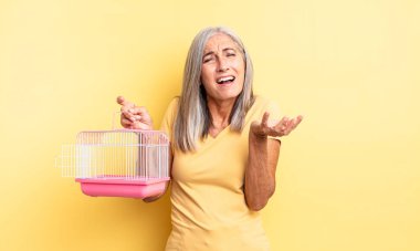 Orta yaşlı, güzel bir kadın umutsuz, sinirli ve stresli görünüyor. evcil hayvan kafesi veya hapishane konsepti