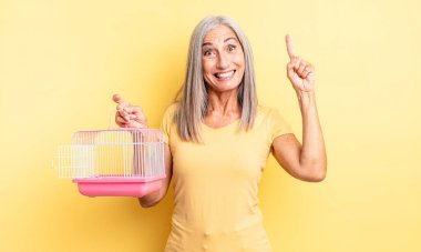 Orta yaşlı, güzel bir kadın bir fikri fark ettikten sonra mutlu ve heyecanlı bir dahi gibi hissediyor. evcil hayvan kafesi veya hapishane konsepti