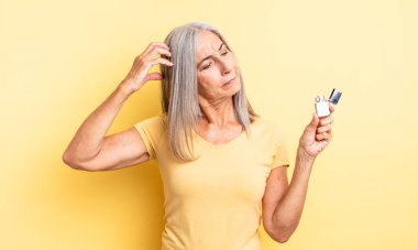 Orta yaşlı, güzel bir kadın şaşkın ve kafası karışık, kaşınıyor. daha hafif kavram