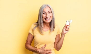 Orta yaşlı güzel bir kadın komik bir şakaya yüksek sesle gülüyor. daha hafif kavram