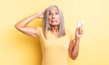 Orta yaşlı, güzel bir kadın stresli, endişeli ya da korkmuş, elleri başının üstünde. daha hafif kavram