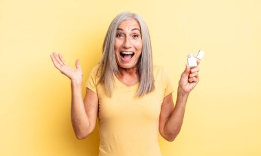 Orta yaşlı, güzel bir kadın inanılmaz bir şey karşısında mutlu ve şaşkın hissediyor. daha hafif kavram